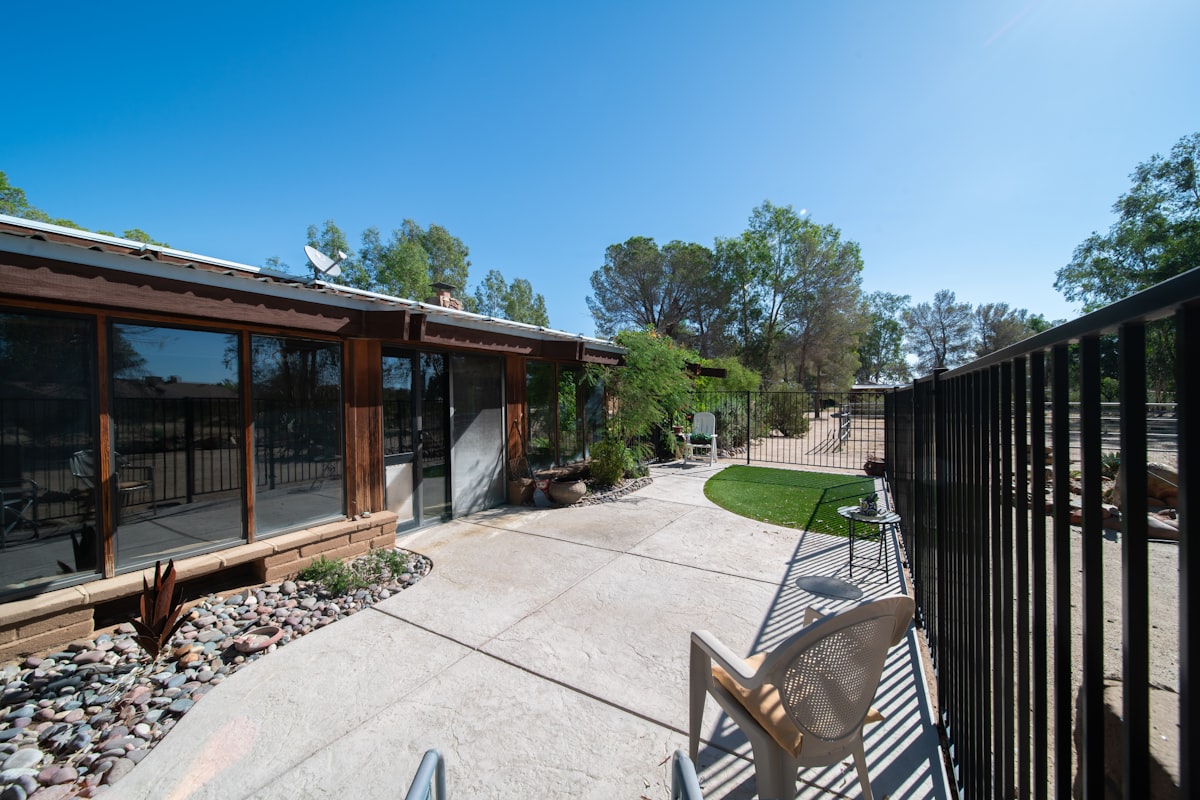 View from inside an Arizona home looking out to a desert backyard through a wall opening